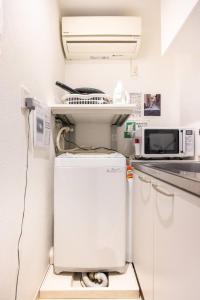 a small kitchen with a refrigerator and a microwave at Dream蒲田 in Tokyo +17 photos