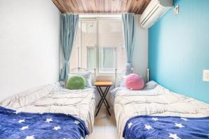 two beds in a room with a window at Dream蒲田 in Tokyo