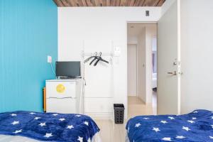 a bedroom with two beds and a television in it at Dream蒲田 in Tokyo