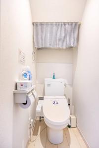 a bathroom with a white toilet in a room at Pet Friendly 7min to Haneda Quick Access to Shinagawa and Tokyo in Tokyo