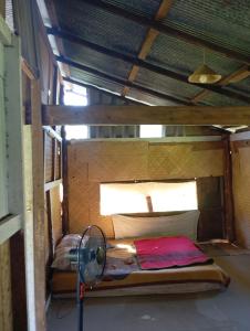 a small room with a bed and a fan at Farmer house on Beverley hill Pai in Pai