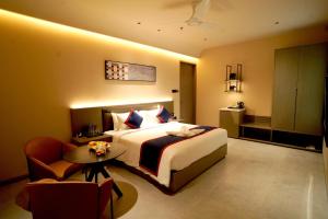 a bedroom with a bed and a table and a chair at Zip By Spree Hotels Nanded in Nānded +43 photos