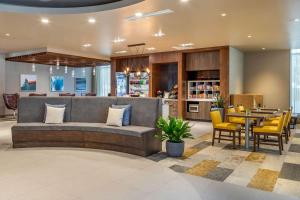 a lobby with a couch and a table and chairs at Cambria Hotel Milwaukee Downtown in Milwaukee