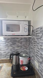 a microwave sitting on top of a kitchen counter at Cozy Staycation in Manila