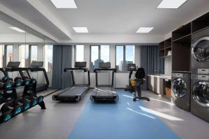 a gym with treadmills and machines in a building at Days Inn by Wyndham Beijing Haidian in Beijing