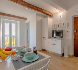a kitchen with a table with bowls of fruit on it at Your Sea Escape in Riva Trigoso