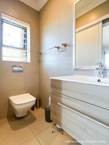 a bathroom with a toilet and a sink at 7Pillars Shiraz in Durbanville