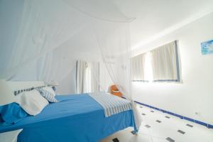 a white bedroom with a blue bed and a window at Hacienda Encanto del Rio in Santa Eularia des Riu +108 photos