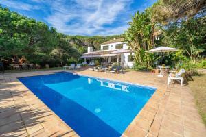 une piscine dans l'arrière-cour d'une maison dans l'établissement Villa Les Oliveres - Lux Houses Experience, à Lloret de Mar