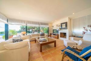 Elle comprend un salon doté d'un mobilier blanc et d'une cheminée. dans l'établissement Villa Les Oliveres - Lux Houses Experience, à Lloret de Mar