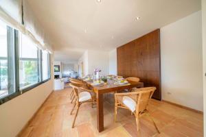 une salle à manger avec une table et des chaises en bois dans l'établissement Villa Les Oliveres - Lux Houses Experience, à Lloret de Mar