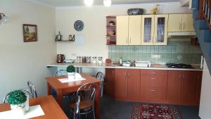 a kitchen with red cabinets and a table and a table and chairs at Noclegi Barbara Pietraszek in Krempachy