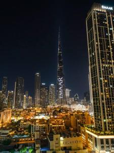 a city skyline at night with a tall building at Royal Vista at Burj Views - Dubai City & Burj Khalifa Views - Brand New Luxury 2BR Apartment in Dubai