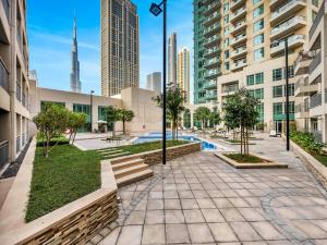a courtyard with a pool in a city with tall buildings at Royal Vista at Burj Views - Dubai City & Burj Khalifa Views - Brand New Luxury 2BR Apartment in Dubai