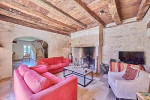 - un salon avec deux canapés rouges et une cheminée dans l'établissement La Forge maison spacieuse 8 pers Lascaux Sarlat, à Saint-Amand-de-Coly
