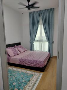 a bedroom with a bed with a ceiling fan and a window at Irdina Homestay in Banting