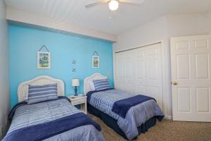 twee bedden in een kamer met blauwe muren bij Seaside at Anastasia D205 in St. Augustine +29 foto's