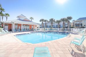 een zwembad met blauwe stoelen en een resort bij Seaside at Anastasia D205 in St. Augustine