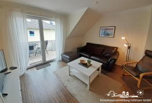 a living room with a couch and a table at 44 Apartment Sunshine Birkenweg 1c OG in Burg auf Fehmarn
