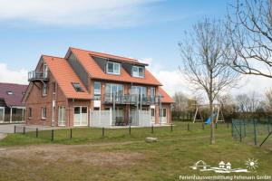 a large brick house with an orange roof at 56 Ferienwohnung im Fritz-Bleyl-Weg 14 DG links in Burg auf Fehmarn