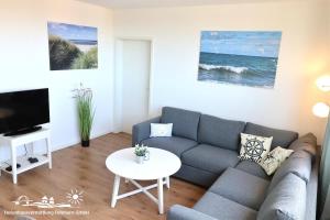 una sala de estar con un sofá y una mesa en 46 Ferienwohnung Burg, en Burg auf Fehmarn