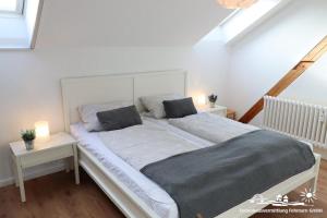 Un dormitorio con una cama grande con dos mesitas de noche. en 46 Ferienwohnung Burg, en Burg auf Fehmarn