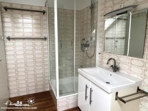 Un baño con lavabo, ducha y espejo. en 46 Ferienwohnung Burg, en Burg auf Fehmarn 8 fotos más
