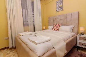 a bedroom with a large bed with two towels on it at Jay Homes - Naiva Heights in Naivasha