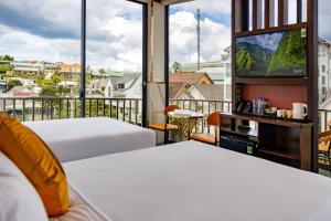 two beds in a room with a balcony with a tv at Phuc Hai Hotel Da Lat in Da Lat +180 photos
