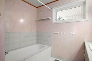 a bathroom with a bath tub and a window at Flott enebolig nær naturen in Lyngen