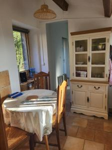 a dining room with a table and a hutch at Gîte à la ferme "Lou Récantou" in Joncels +9 photos