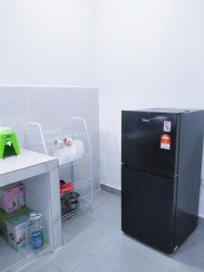 a kitchen with a black refrigerator in a room at De' Balok Homestay in Kuantan