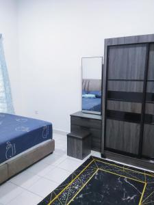 a bedroom with a bed and a flat screen tv at De' Balok Homestay in Kuantan