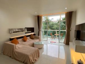un salon avec un canapé et une grande fenêtre dans l'établissement Sealinks Ocean Vista, à Ấp Ngọc Hải