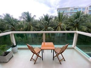 un balcon avec une table, des chaises et des palmiers dans l'établissement Sealinks Ocean Vista, à Ấp Ngọc Hải