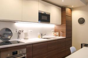 a kitchen with a sink and a microwave at Charming T2 with balcony near the Bastille in Paris +17 photos