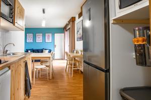 a kitchen and dining room with a stainless steel refrigerator at CozySerenity, Orelle & Les 3 Vallées in Orelle