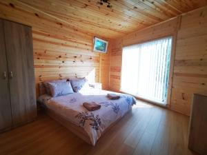 a bedroom with a bed in a log cabin at Lakeview Estate Chalet in Staro Myasto