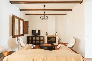 a living room with a bed and a fireplace at Casa Higuera de la Sierra in Higuera de la Sierra +9 photos