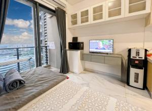 Schlafzimmer mit einem Bett, einem TV und einem Balkon in der Unterkunft Cozy Studio Skyhouse Apt near ICE BSD with pool & Gym by 2ndHome in Cilenggang