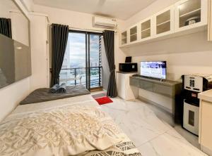 ein Schlafzimmer mit einem Bett und einem großen Fenster in der Unterkunft Cozy Studio Skyhouse Apt near ICE BSD with pool & Gym by 2ndHome in Cilenggang
