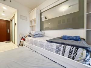 a bedroom with a large bed with a large window at Cozy Studio Skyhouse Apt near ICE BSD with pool & Gym by 2ndHome in Cilenggang +17 photos