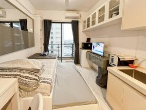 a small room with a bed and a desk at Cozy Studio Skyhouse Apt near ICE BSD with pool & Gym by 2ndHome in Cilenggang