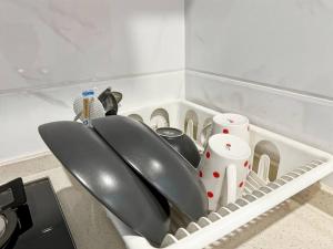 eine Küchenspüle mit zwei Utensilien in einem Geschirrständer in der Unterkunft Cozy Studio Skyhouse Apt near ICE BSD with pool & Gym by 2ndHome in Cilenggang