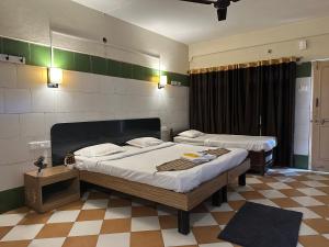 Un dormitorio con dos camas en una habitación. en Cibara Comforts - Budget Lodge in Harihar, en Harihar