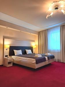 sypialnia z dużym łóżkiem i żyrandolem w obiekcie Spa Hotel Gloria w mieście Przemyśl