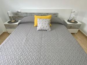 a bed with a gray bedspread and two lamps at Casa fina y pepe in Algar