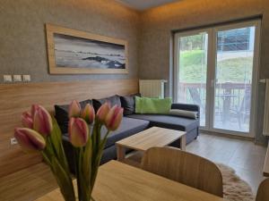 a living room with a couch and a table with flowers at Apartment Jasna - Lucky in Demanovska Dolina