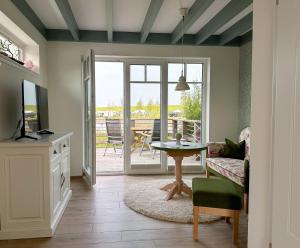 a living room with a couch and a tv and a table at Fischerhäuschen am Kurpark in Neuharlingersiel