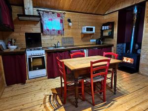 a kitchen with a wooden table and a stove at Le Noisetier in Mélisey